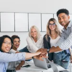 equipe jovem com as mãos unidas no centro da mesa