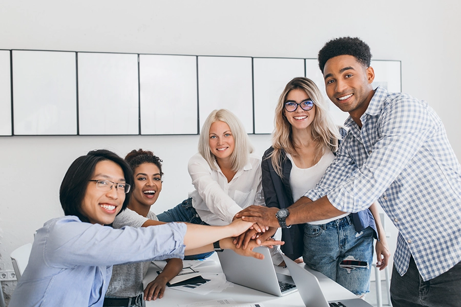 equipe jovem com as mãos unidas no centro da mesa